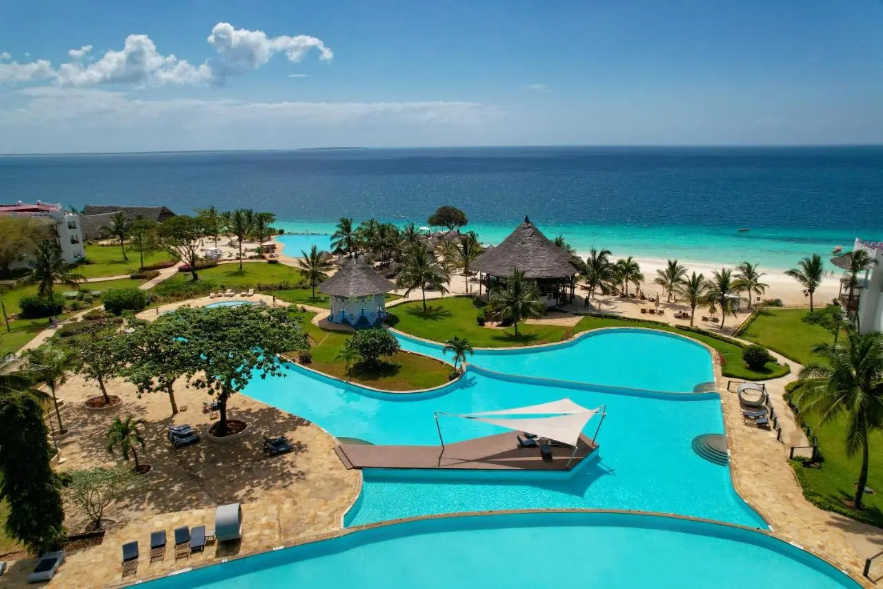 Piscinas do Royal Zanzibar Beach Resort com bar e plataforma coberta por velas de sombra