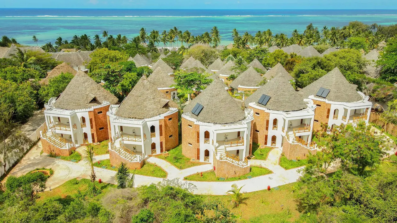 Edifícios de alojamento do Bluebay Beach Resort & Spa entre jardins e o mar
