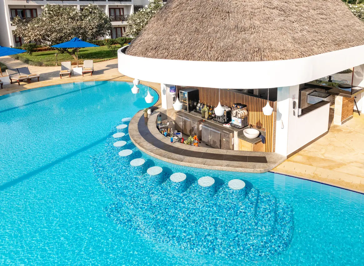 Bancos submersos junto ao bar da piscina do Nungwi Beach Resort by Turaco