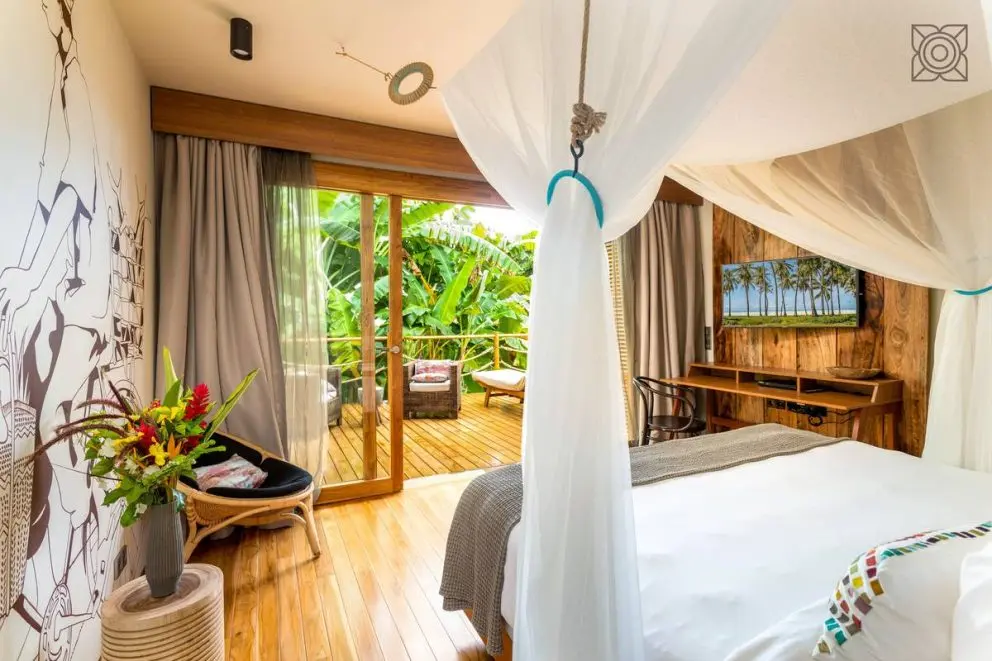 Quarto do Zuri Zanzibar com mosquiteiro e portas abertas para o terraço